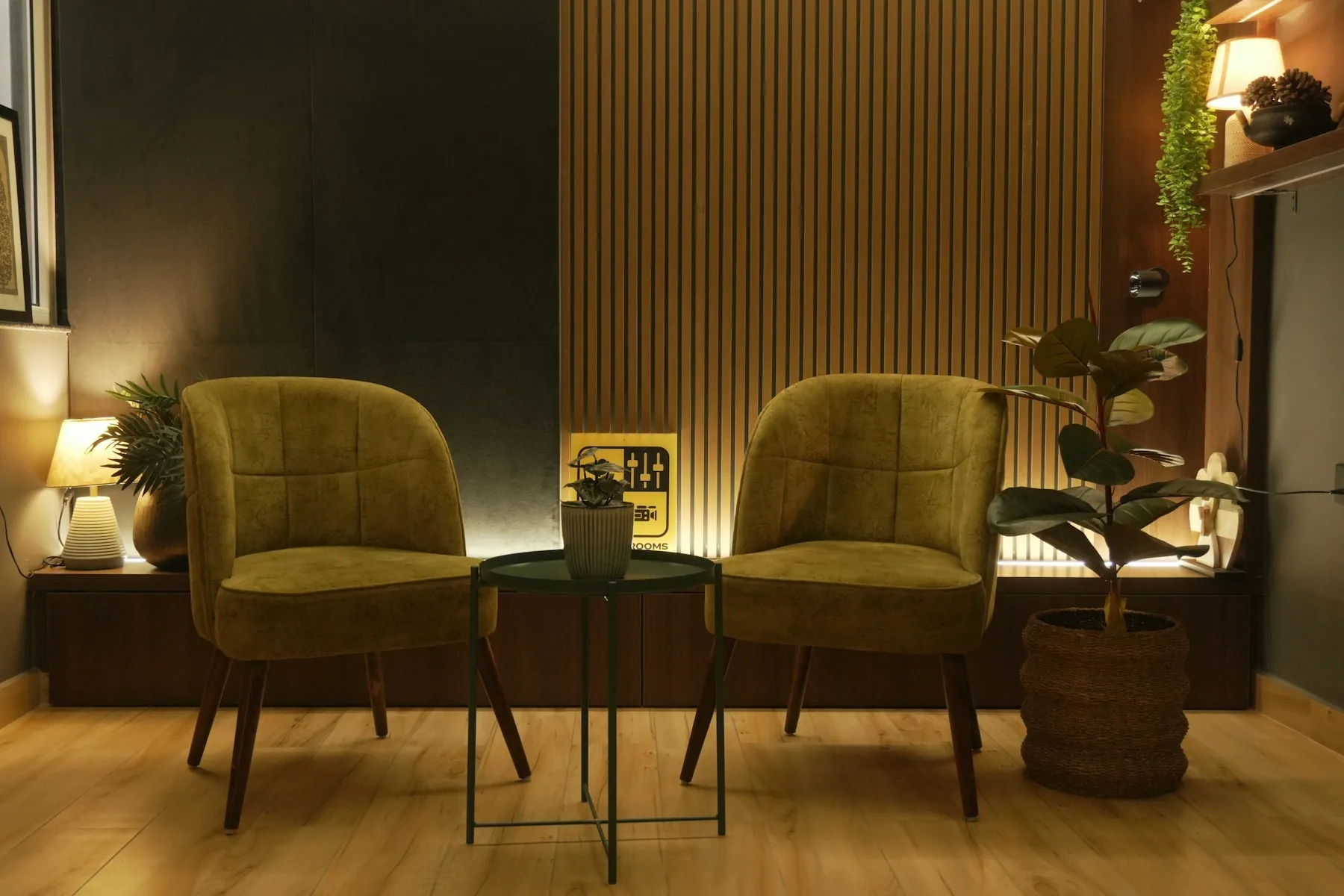 A warm, modern lounge with two olive armchairs